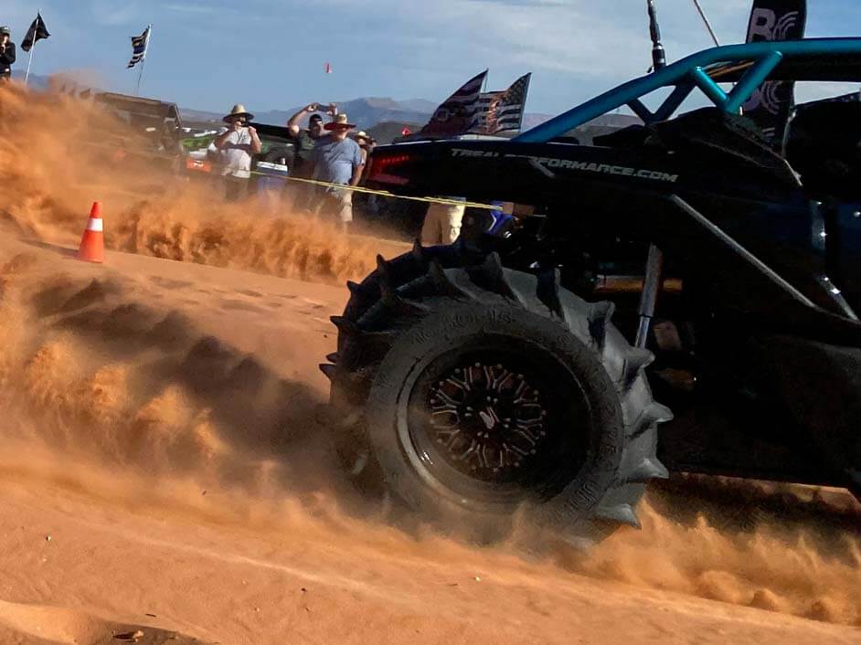 Rear paddle tires kicking up sand in the desert.