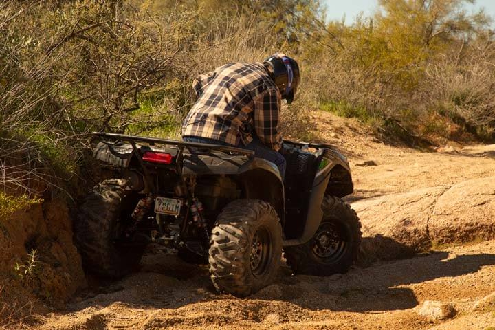 Kawasaki Brute Force stuck in a rut on a rock trail.